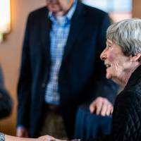 A guest is shaking Ellen Thompson's hand.